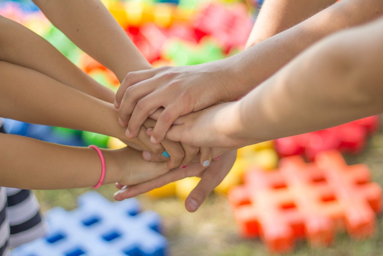 Kinder, die Ihre Hände aufeinanderstapeln